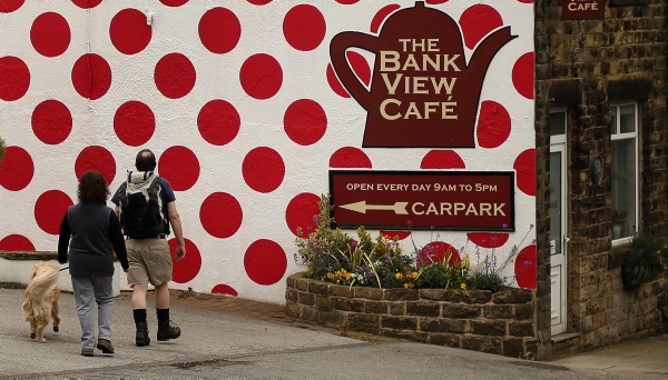Walkers arrive at a cafe painted with the polka dots of the King of the Mountains jersey on the route of the Tour de France in Langsett